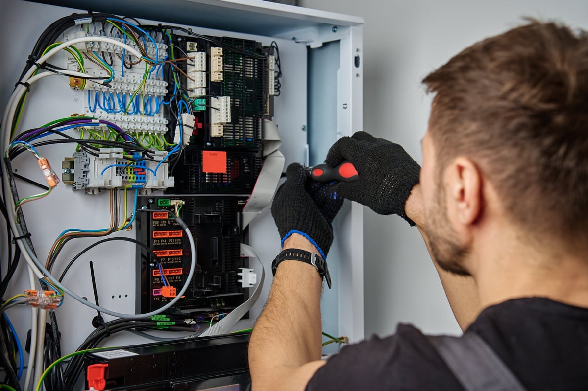 Técnico trabajando en cableado de sistema eléctrico